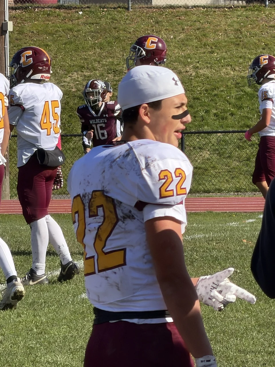 Logan on the sideline in his number 22 jersey and a backward white cap